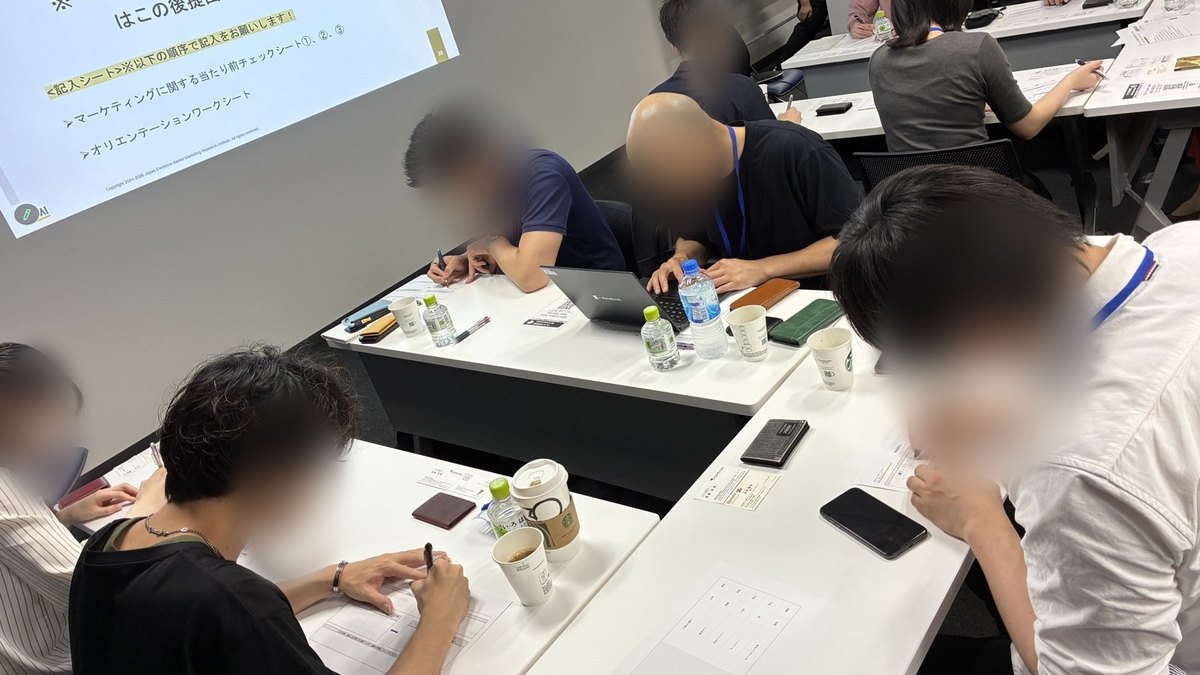 EBM基礎コースのディスカッション回。受講生がワークシートに記入しグループで議論している(顔はぼかし処理)